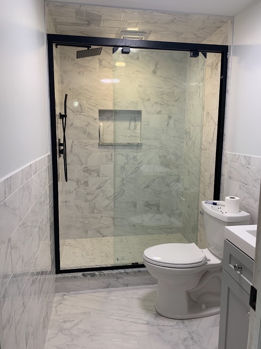 A marble subway-tile shower with a black-framed glass door